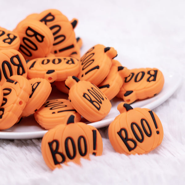 front view of a pile of Boo Pumpkin Silicone Focal Bead Accessory