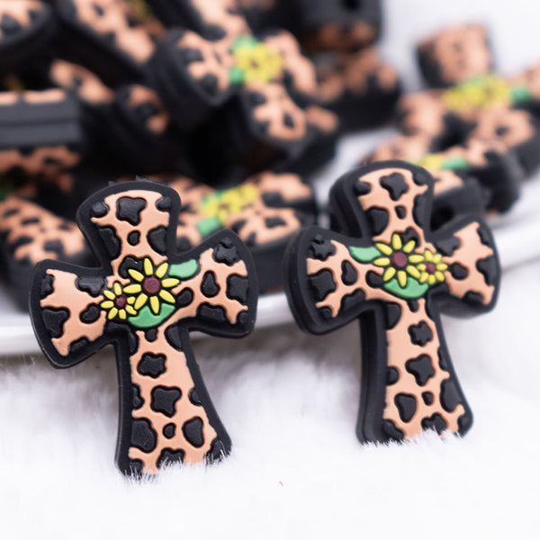 front view of a pile of Cow Print Cross with Flower Silicone Focal Bead Accessory