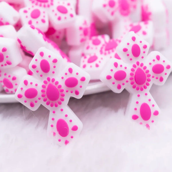 close up view of a pile of Cross with Pink print silicone focal bead