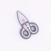 top view of a pile of Scissors Gray Silicone Focal Bead Accessory