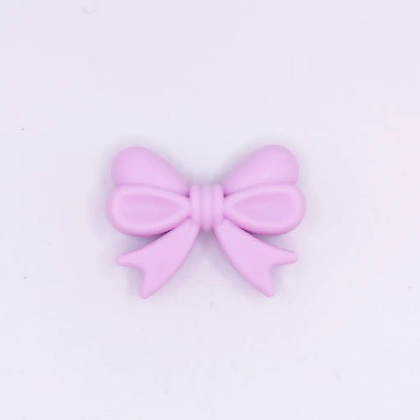 top view of a pile of 25mm Light Purple Bow Knot silicone bead