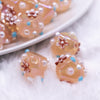 close up view of a pile of 16mm Champagne Gold with Flower luxury acrylic beads
