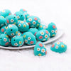 front view of a pile of 3D Teal Egg with Flowers Silicone Focal Bead Accessory