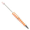 top view of a orange and white plaid DIY Plastic Beadable Pens - The Printed Collection