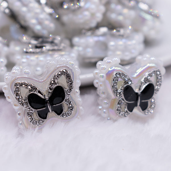 close up view of a pile of 23mm Black butterfly with rhinestone and pearl surround acrylic bead