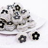 front view of a pile of 27mm Black flower with rhinestone and pearl surround acrylic bead