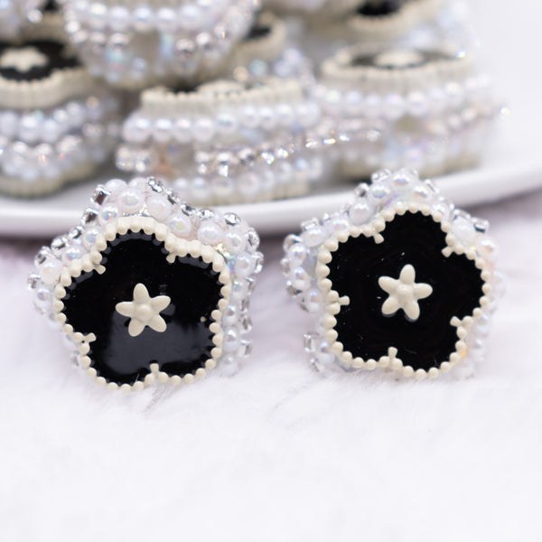 close up view of a pile of 27mm Black flower with rhinestone and pearl surround acrylic bead