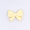 top view of a pile of 25mm Cream Yellow Bow Knot silicone bead