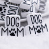 front view of a pile of Dog Mom with paw print Silicone Focal Bead Accessory