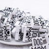 close up view of a pile of Dog Mom with paw print Silicone Focal Bead Accessory