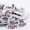 close up view of a pile of Dog Mom with red Paw print Silicone Focal Bead Accessory