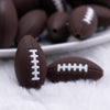 front view of a pile of Brown Football Silicone Focal Bead Accessory