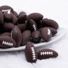 close up view of a pile of Brown Football Silicone Focal Bead Accessory
