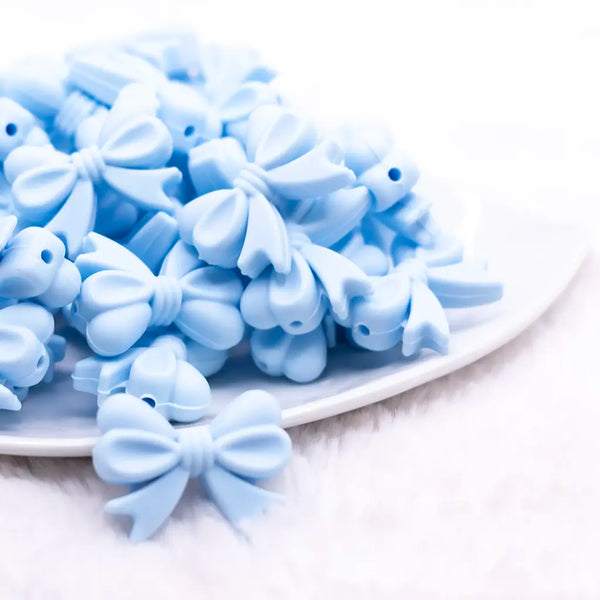 front view of a pile of 25mm Pastel Blue Bow Knot silicone bead