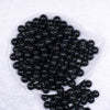 Top view of a pile of 12mm Black with Glitter Faux Pearl Acrylic Bubblegum Beads - 20 Count