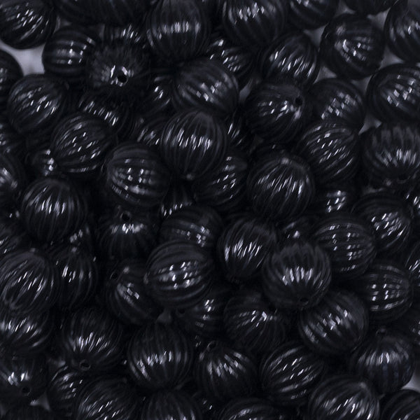 Close up view of a pile of 12mm Black Opaque Pumpkin Shaped Bubblegum Bead