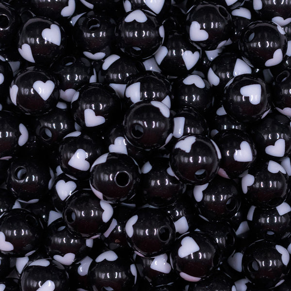 Close up view of a pile of 12mm Black with White Heart Chunky Acrylic Bubblegum Beads [20 Count]