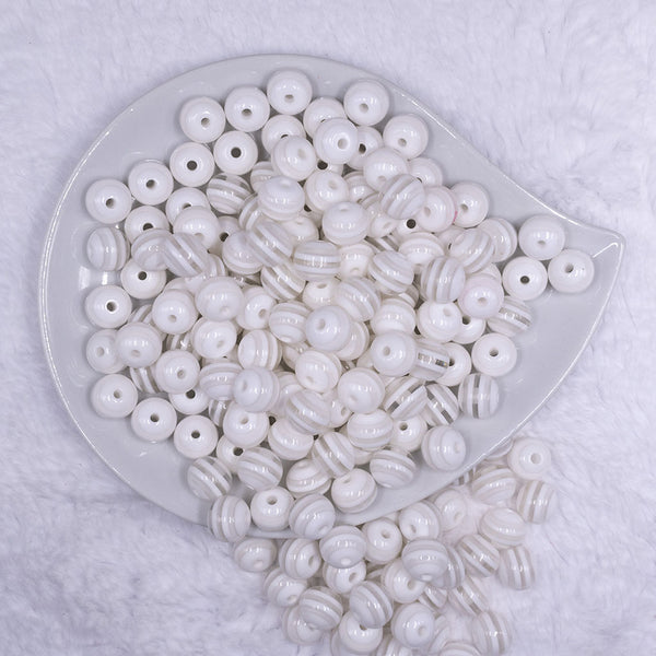 Top view of a pile of 12mm Clear with White Stripes Resin Chunky Bubblegum Beads