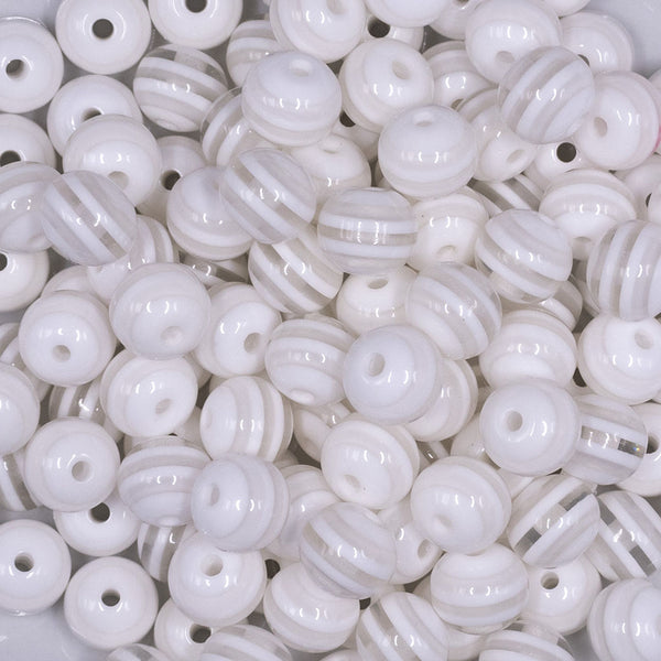 Close up view of a pile of 12mm Clear with White Stripes Resin Chunky Bubblegum Beads