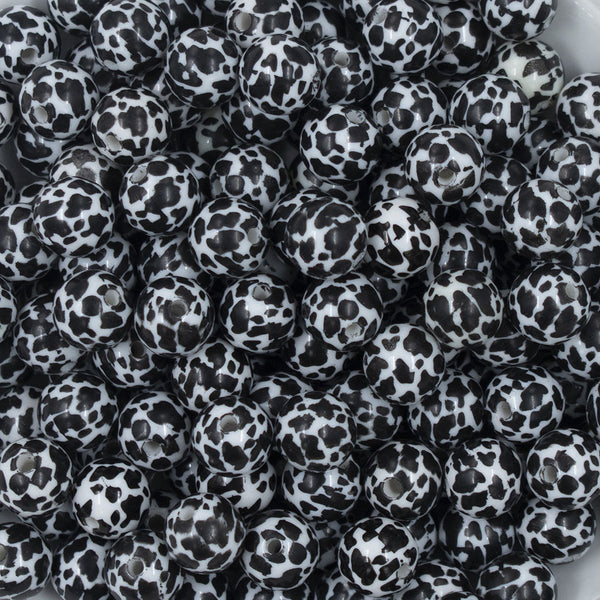 Close up view of a pile of 12mm Black & White Cow Print Chunky Acrylic Bubblegum Beads - 20 Count