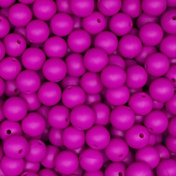 Close up view of a pile of 12mm Hot Pink Round Silicone Bead