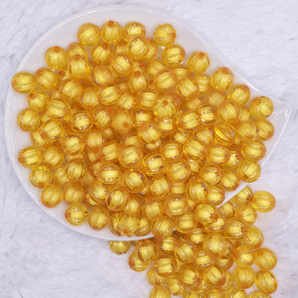 top view of a pile of 12mm Mustard Yellow Transparent Pumpkin Shaped Bubblegum Beads