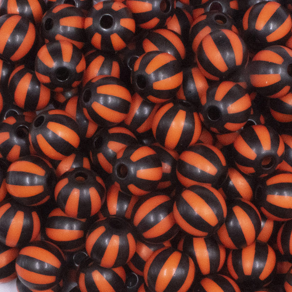 close up view of a pile of 12mm Orange with Black Stripe Beach Ball Bubblegum Beads - 20 count