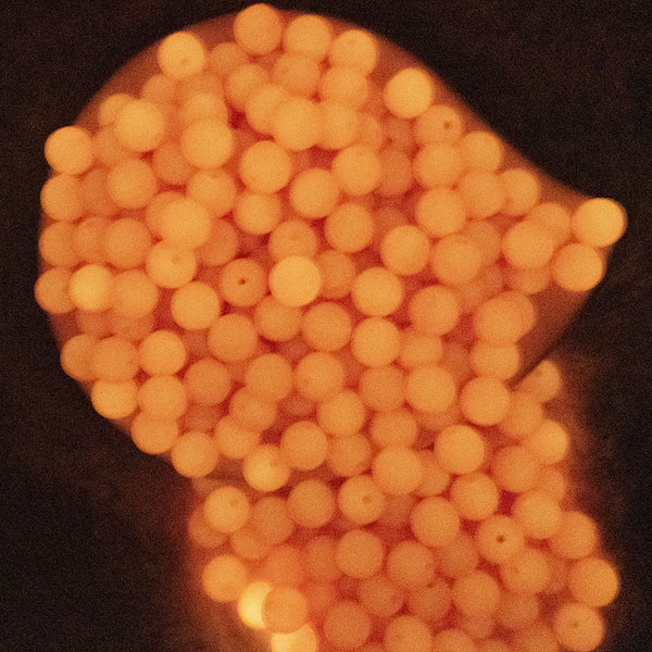 Top view of a pile of glowing 12mm Orange Glow in the Dark Bubblegum Beads [20 & 50 Count]