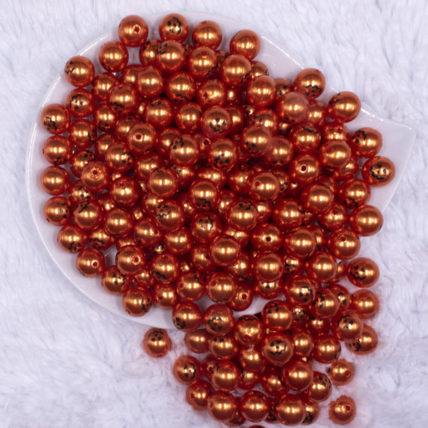 top view of a pile of 12mm Jack O Lantern Pearl Pumpkin Face Halloween print Bubblegum Beads