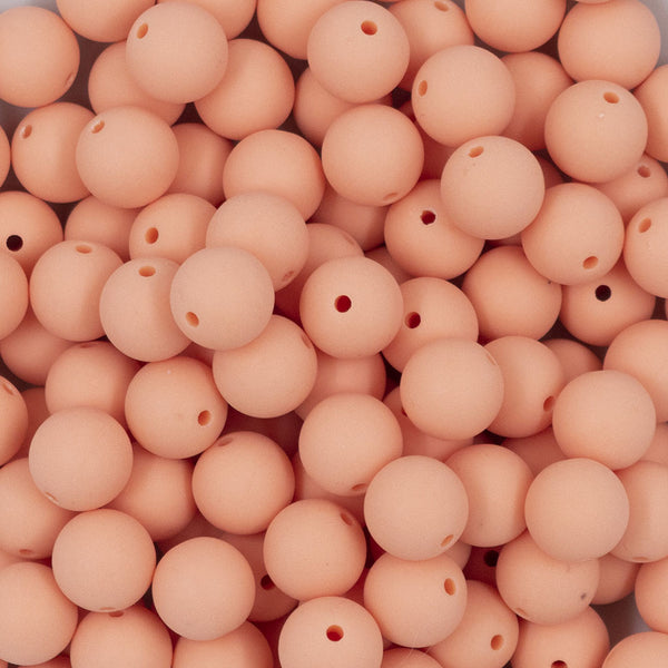 Close up view of a pile of 12mm Peach Matte Acrylic Bubblegum Beads