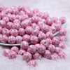 front view of a pile of 12mm Pink & White Cow Print Chunky Acrylic Bubblegum Beads - 20 Count