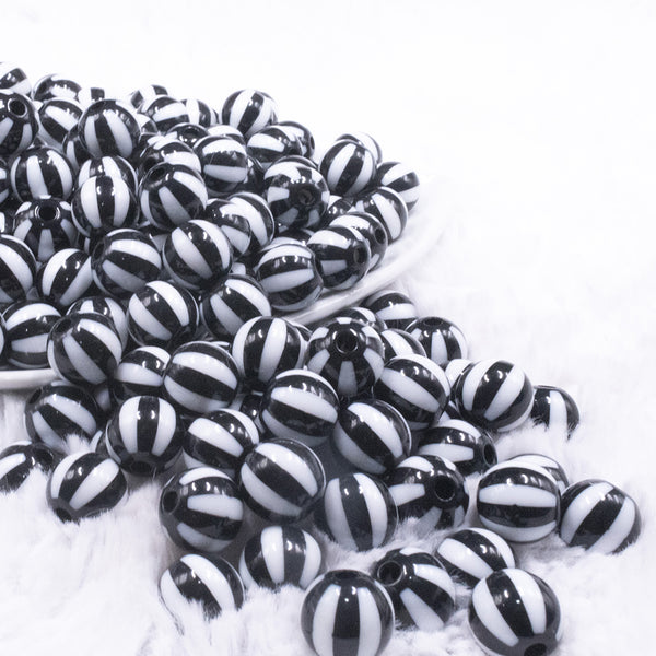 front view of a pile of 12mm Black with White Stripe Beach Ball Bubblegum Beads - 20 count