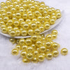 Front view of a pile of 12mm Yellow with Glitter Faux Pearl Acrylic Bubblegum Beads - 20 Count