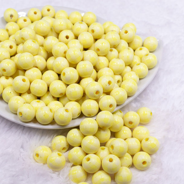 Front view of a pile of 12mm Pastel Yellow Plaid Print Chunky Acrylic Bubblegum Beads - 20 Count