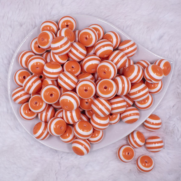 Top view of a pile of 16mm Orange with White Stripe Bubblegum Beads