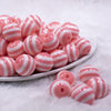 Front view of a pile of 16mm Salmon Pink with White Stripe Bubblegum Beads