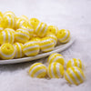 Front view of a pile of 16mm Yellow with White Stripe Bubblegum Beads