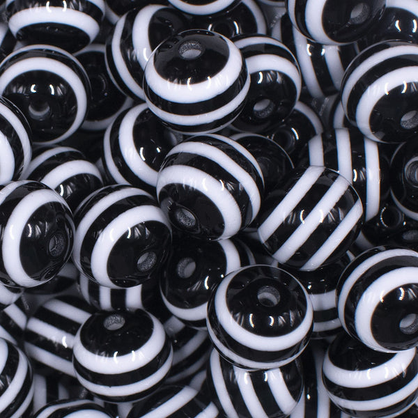 Close up view of a pile of 16mm Black with White Stripe Bubblegum Beads