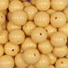 Close up view of a pile of 16mm Blonde Yellow Solid Acrylic Bubblegum Jewelry BeadsFront view of a pile of 16mm Blonde Yellow Solid Acrylic Bubblegum Jewelry Beads