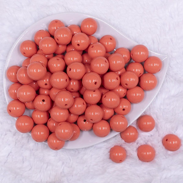 Top view of a pile of 16mm Coral Orange Solid Acrylic Bubblegum Jewelry Beads