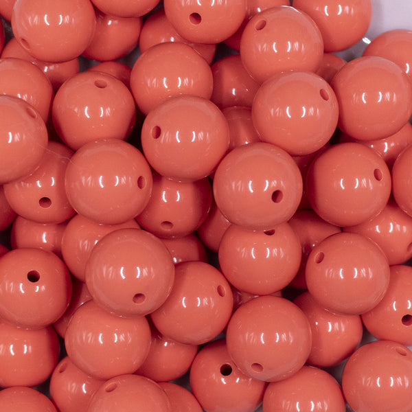 Close up view of a pile of 16mm Coral Orange Solid Acrylic Bubblegum Jewelry Beads