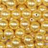 Close up view of a pile of 16mm Golden Yellow Faux Pearl Acrylic Bubblegum Jewelry Beads