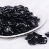 Front view of a pile of 20mm Black Opaque Wavy Flat Shaped Jewelry Bead