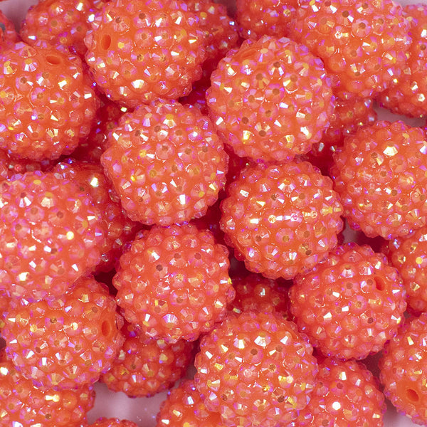 Close up view of a pile of 20mm Neon Orange Rhinestone AB Bubblegum Beads