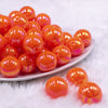 Front view of a pile of 20MM Orange Neon AB Solid Chunky Bubblegum Beads