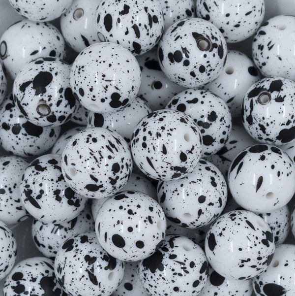 Close up view of a pile of 20mm White with Black Splatter Chunky Acrylic Bubblegum Beads