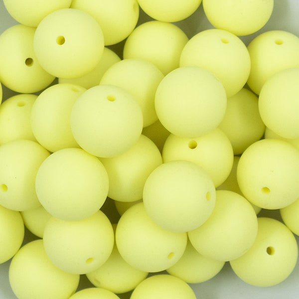 Close up view of a pile of 20mm Yellow Matte Solid Bubblegum Beads