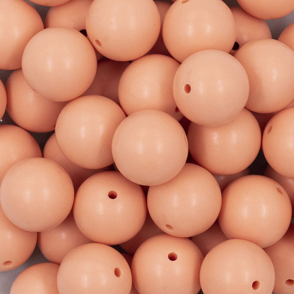 Close up view of a pile of 20mm Peach Matte Solid Bubblegum Beads