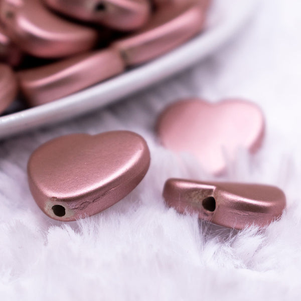 Macro view of a pile of 20mm Rose Matte Rubberized Style Heart Beads