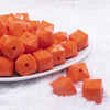 front view of a pile of 20mm Orange Cube Faceted Bubblegum Beads
